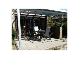 Überdachte Terrasse mit Gartenmöbeln