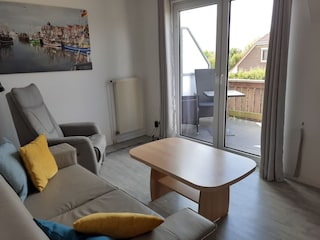 Fernsehsessel mit Ledercouch und Blick auf Balkon