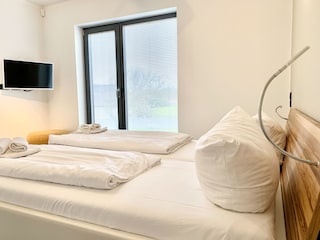 Schlafzimmer im EG mit TV – bequem & nah am Bad.