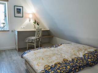 Schlafzimmer mit kleinem Schreibtisch und Schrank
