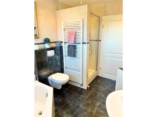 Großes Badezimmer mit Dusche und Wanne