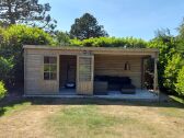 Terrasse mit hochwertigen gartenmöbeln.Holzhütte istzu