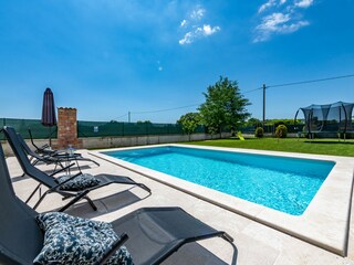 Entspannen Sie sich auf den Liegestühlen am Pool.