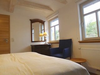 Schlafzimmer mit Doppelbett - Blick in den Garten