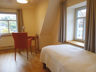 Schlafzimmer mit Einzelbett und Schreibtisch