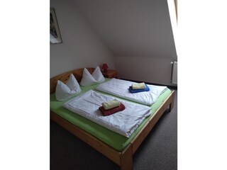 Schlafzimmer mit Doppelbett und Bad