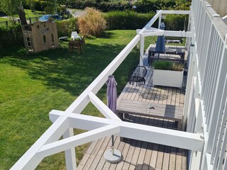 Balkon mit Blick in Garten mit Möbeln und Spielhaus
