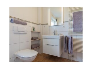 Toilette mit Waschbecken und Handtuchhalter