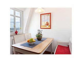 Der Essbereich in der Küche mit Meer im Fenster.