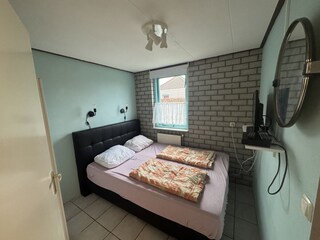Schlafzimmer mit Boxspringbett und TV