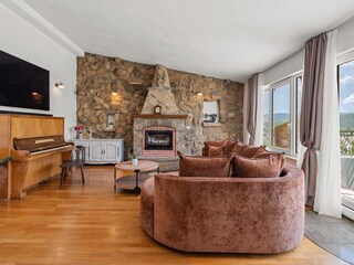Living area with piano, fireplace and exit to terrace