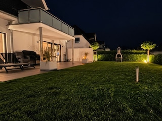Beleuchteter, eingezäunter Garten mit Terrasse