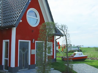 Blick auf den Hauseingang mit Schiff im Garten