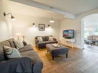 Wohnzimmer mit 2 Sofas, TV und Hygge-Kamin