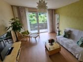 Wohnenzimmer mit Schlafcouch und Balkon