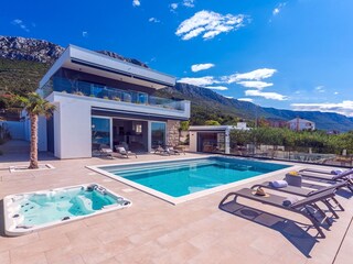 The outdoor area offers a heated private pool, jacuzzi