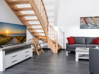 Der stilvolle Wohnbereich überzeugt mit großen Flachbild-TV