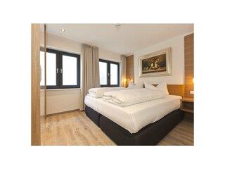 Das Schlafzimmer mit Doppelbett und Kleiderschrank