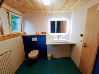 Badezimmer mit offener Regendusche und Fußbodenheizung