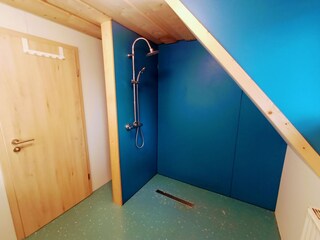 Badezimmer mit offener Regendusche und Fußbodenheizung