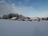 Unser Hof eingebettet in Schnee