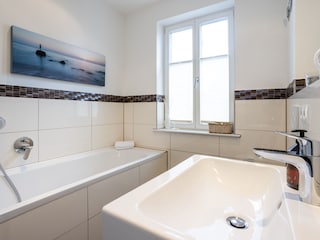 Badezimmer mit Fenster und Badewanne