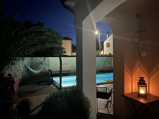 Blick von der Veranda auf den beleuchteten Pool mit uml