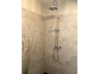 Große Walk-in-Regendusche mit erwärmten Lavasteinboden