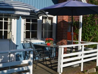 Terrasse mit Tisch, Stühlen und Sonnenschirmen