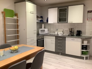 Küche mit Abstellregal und Essecke