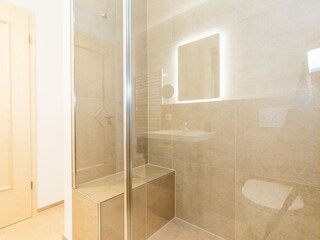 Dusche mit Sitzgelegenheit und Handbrause