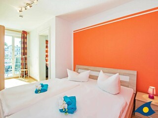 Schlafzimmer mit Doppelbett und Zugang zum Balkon