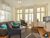 Wohnzimmer mit Couch und TV und Zugang zur Loggia