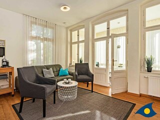 Wohnzimmer mit Couch und TV und Zugang zur Loggia