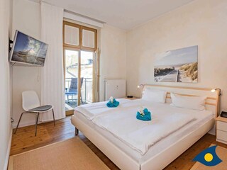 Schlafzimmer 1 mit Doppelbett und Zugang zu Balkon 2