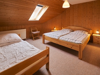 Schlafzimmer mit Doppelbett und Kinderbett