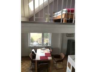 Blick von der Wendeltreppe auf Esstisch und Empore