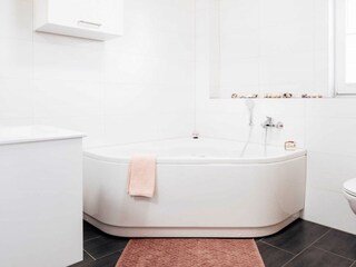 ... gelangen Sie in das Wellnessbad mit Whirlpool.