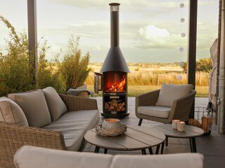 Überdachte Lounge mit Grillkamin und Blick in Natur