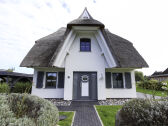 Front view of the house with a thatched roof