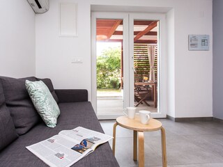 Die graue Couch kann zu einem Bett ausgezogen werden.
