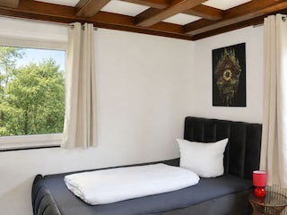 Schlafzimmer mit Einzelbett und Naturblick