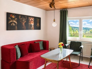 Wohnzimmer mit TV und 100 Jahre alten Klavier