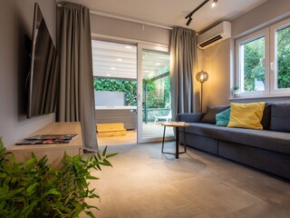 Die graue Couch kann zu einem Bett ausgezogen werden.
