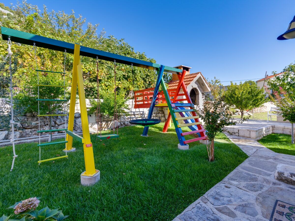 Spielplatz mit Schaukel und Rutsche neben dem BBQ