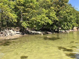 Der Naturstrand mit klarem, ruhigen Wasser