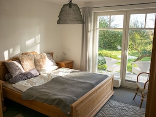 Schlafzimmer mit Doppelbett und angrenzender Terrasse