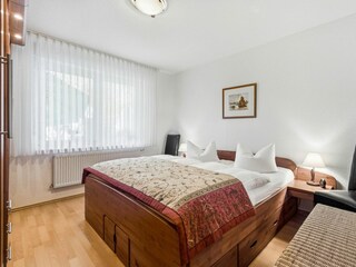 Schlafzimmer mit Doppelbett und großem Kleiderschrank