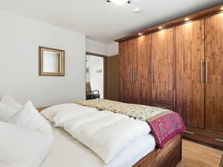 Schlafzimmer mit Doppelbett und großem Kleiderschrank