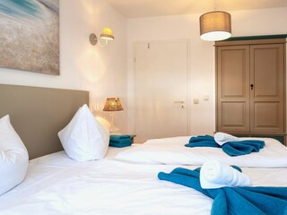 Schlafzimmer mit Doppelbett und Kleiderschrank